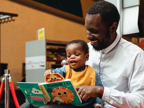 Een papa leest voor aan zijn zoontje.