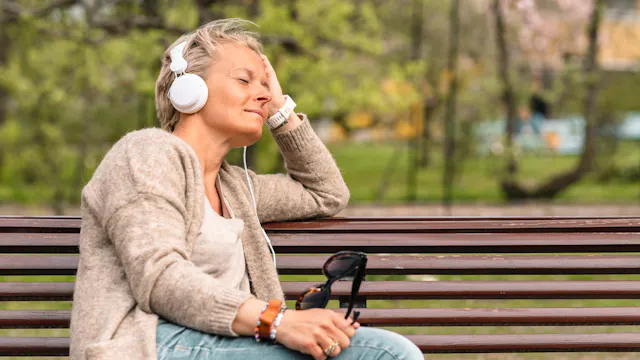 foto rustende dame op een bankje aan het genieten van de muziek