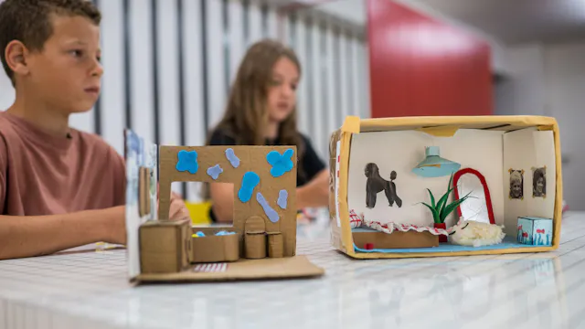 Kartonnen knutselwerkjes met kinderen op de achtergrond