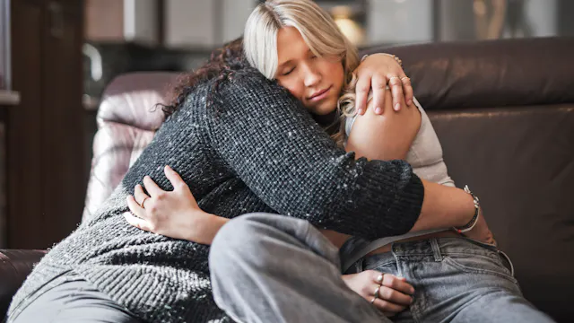 Moeder omhelst dochter in troostende knuffel