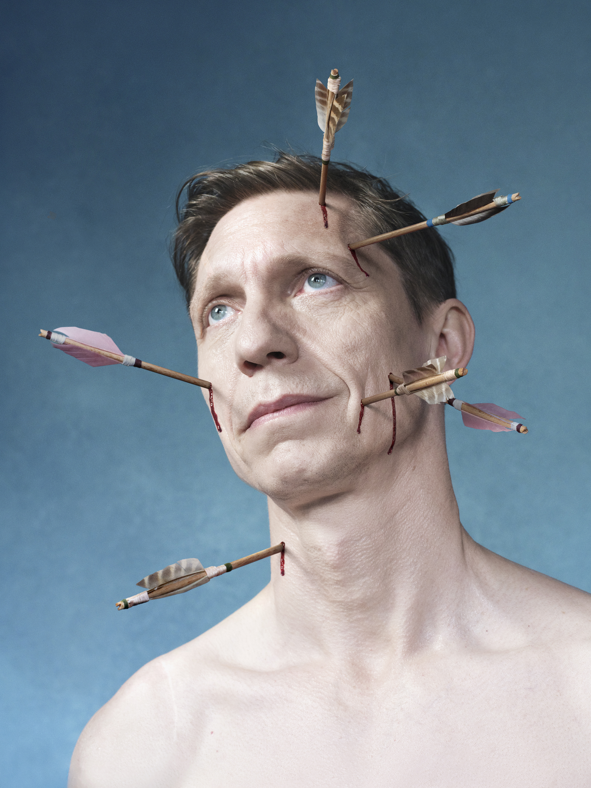 Afbeelding van een persoon met pijlen in het hoofd en gezicht.