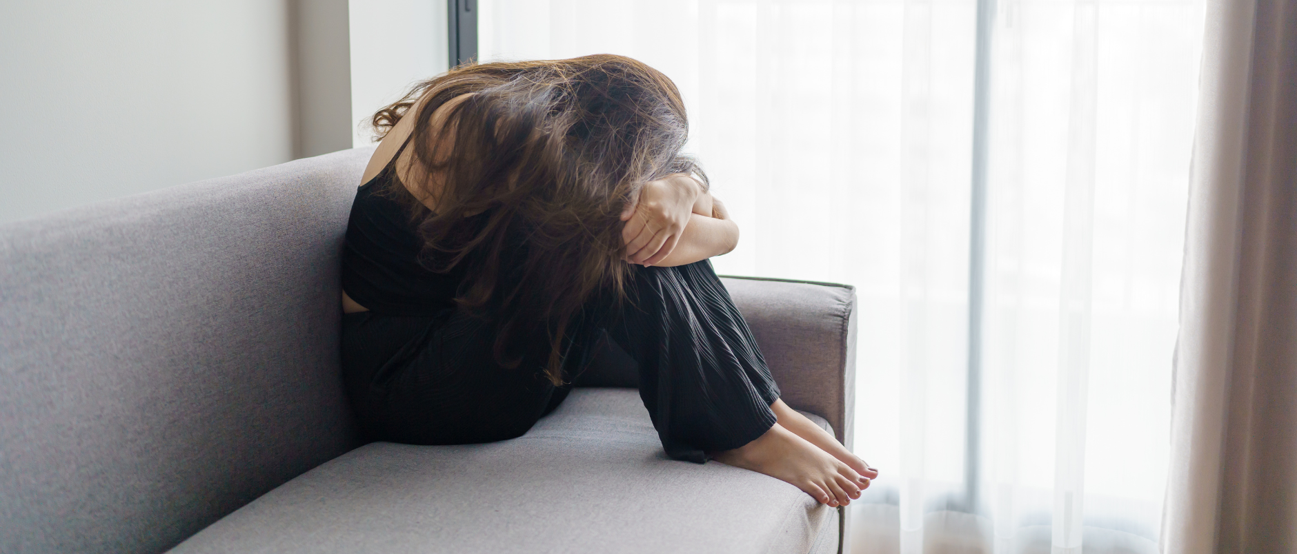 jonge vrouw op zetel inelkaargedoken