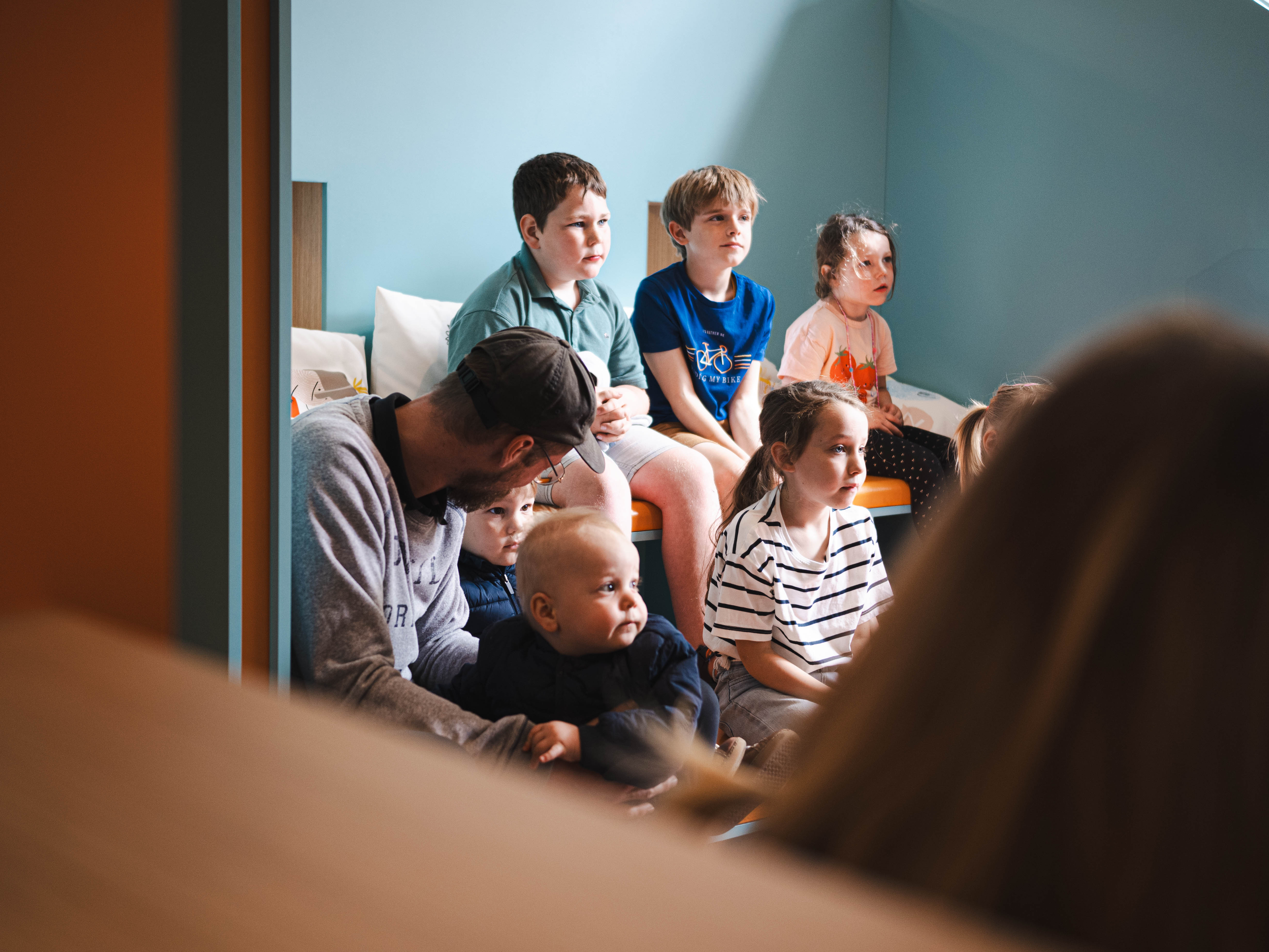 Kinderen luisteren naar een voorlezer in het verteltheater van bib Izegem
