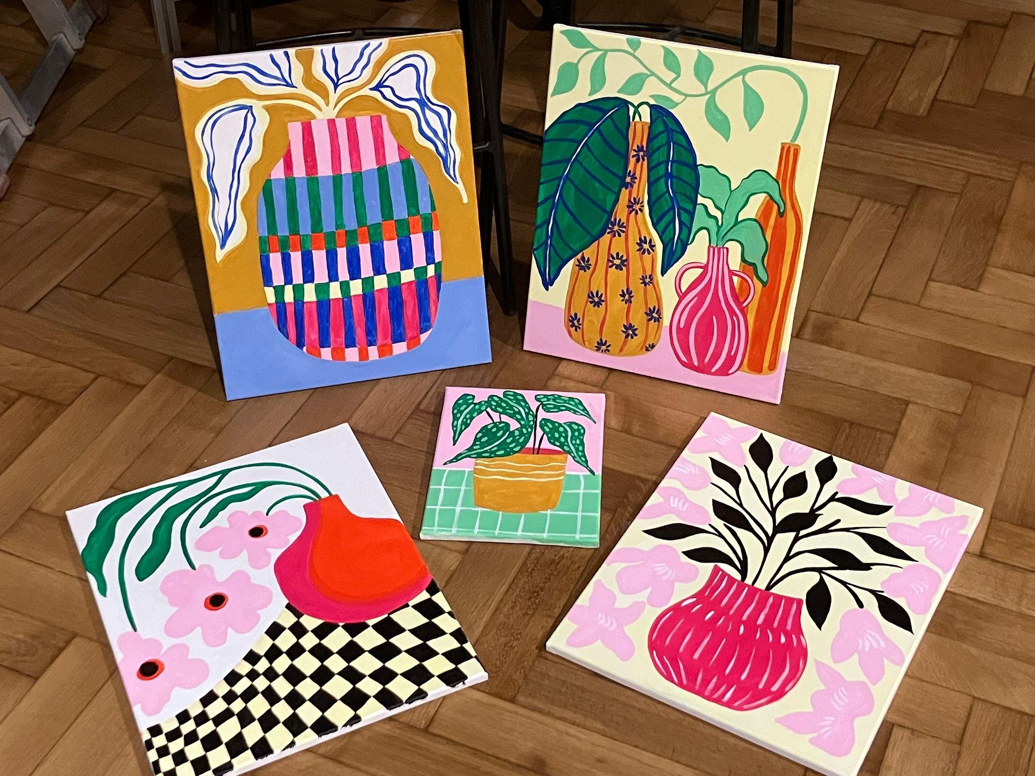 5 kleurrijke schilderijtjes uitgestald