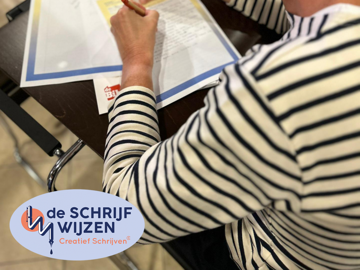 Een persoon met een gestreepte trui zit aan een tafeltje en schrijft iets op.