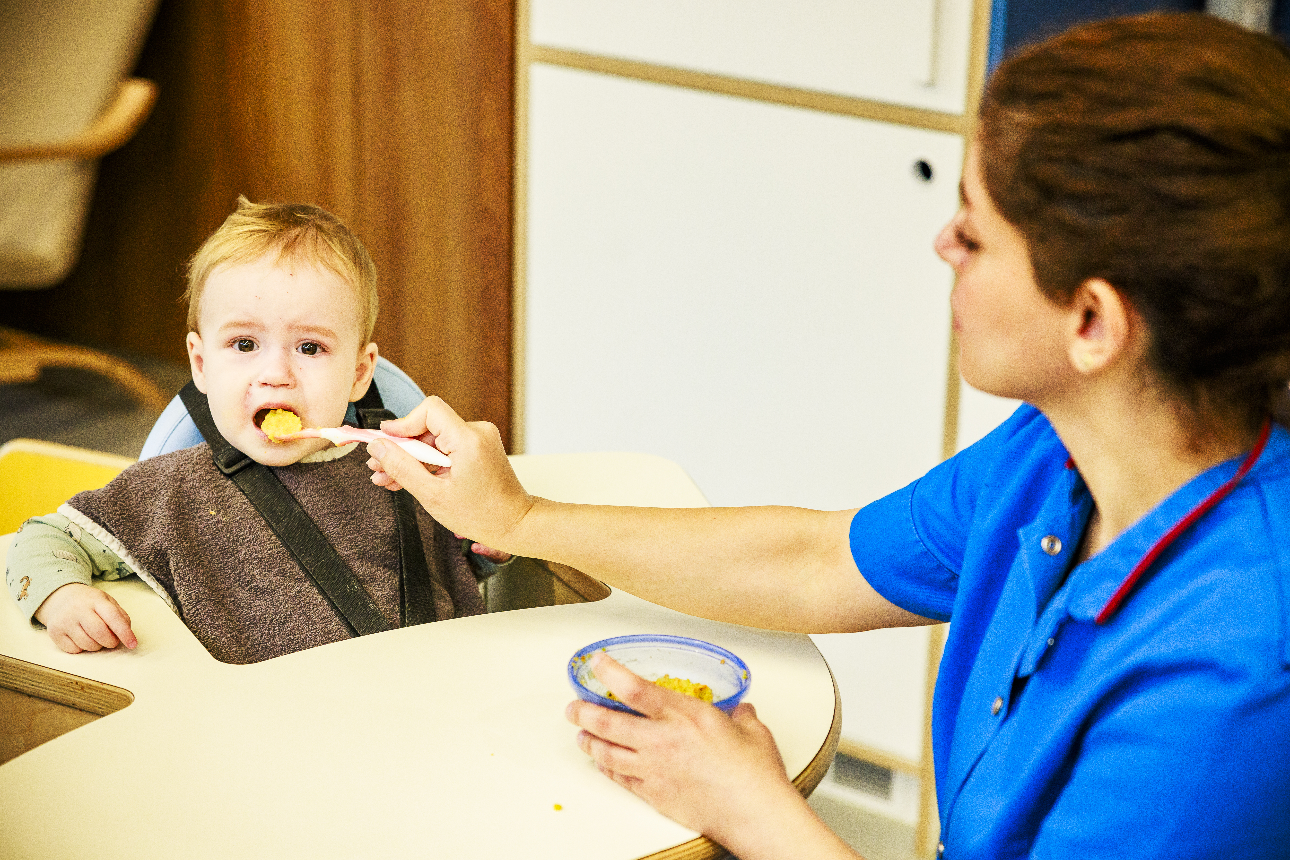 Een peuter krijgt groentepap.