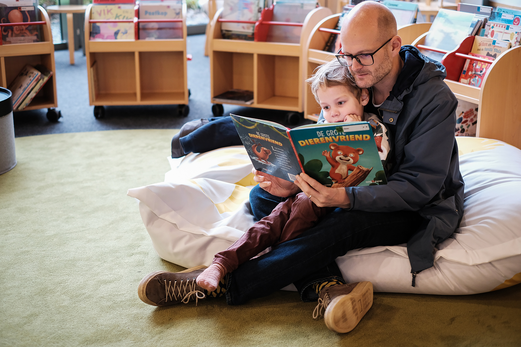 man en kind kijken in boek