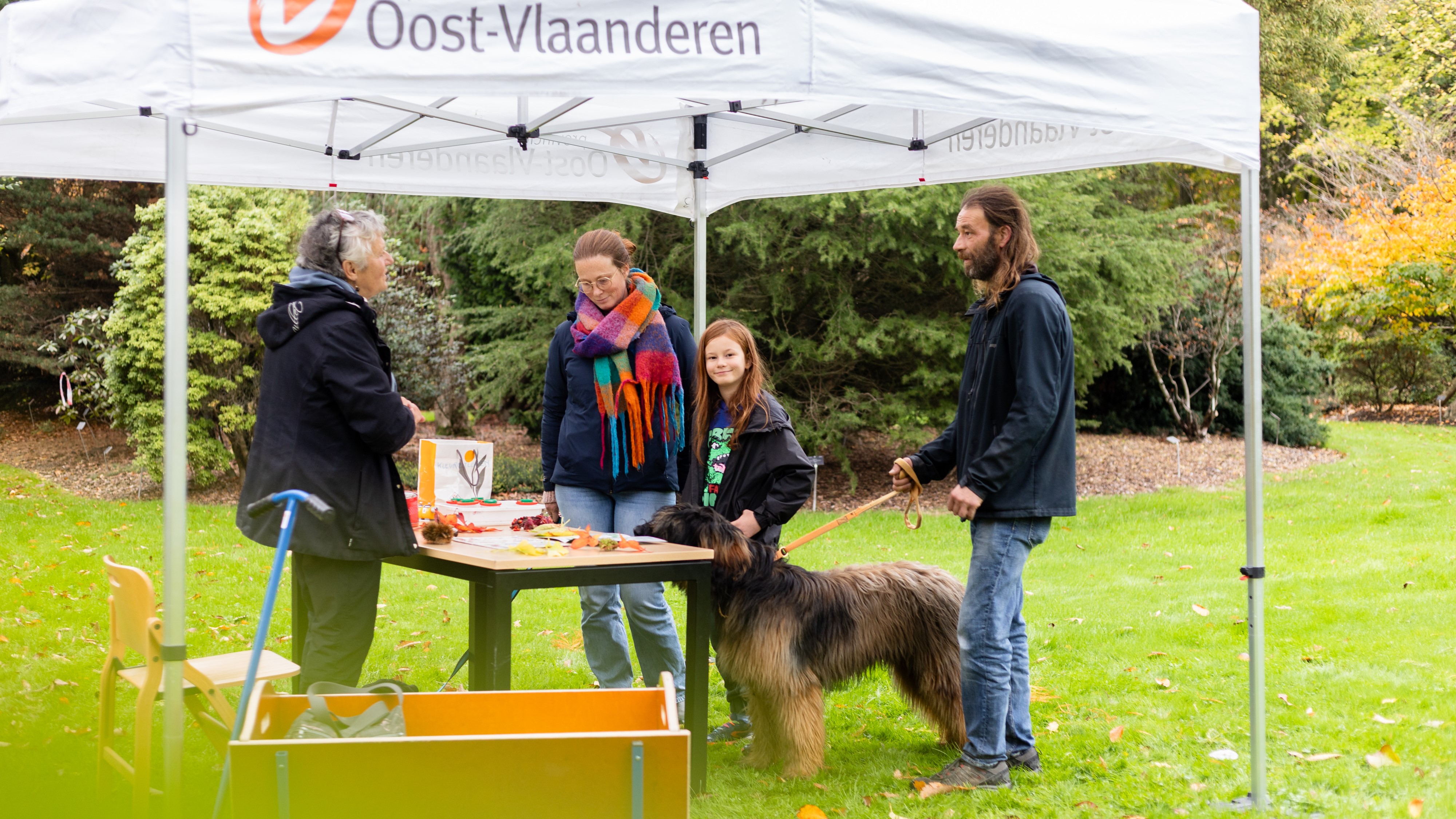 Twee volwassenen en kind staan in de natuurtent bij een gids