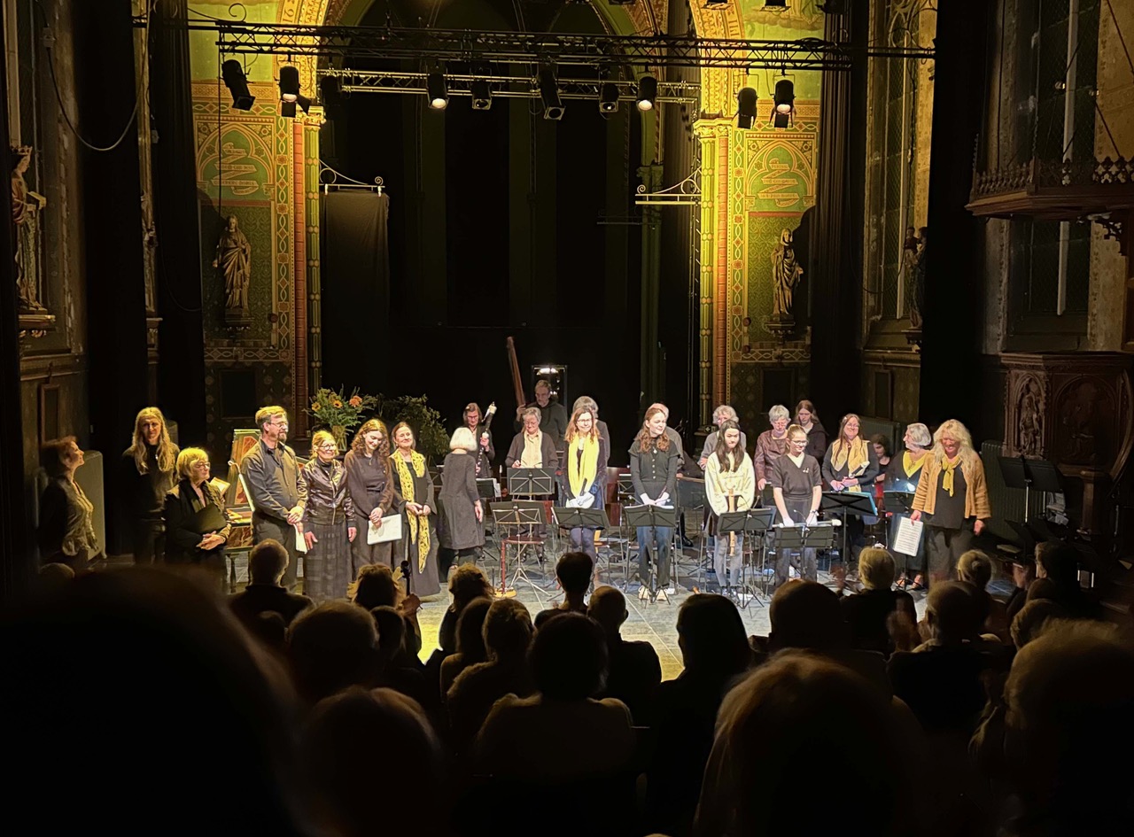 Foto publiek op drug muzikanten in kapel in warm geel licht, ontvangen applaus