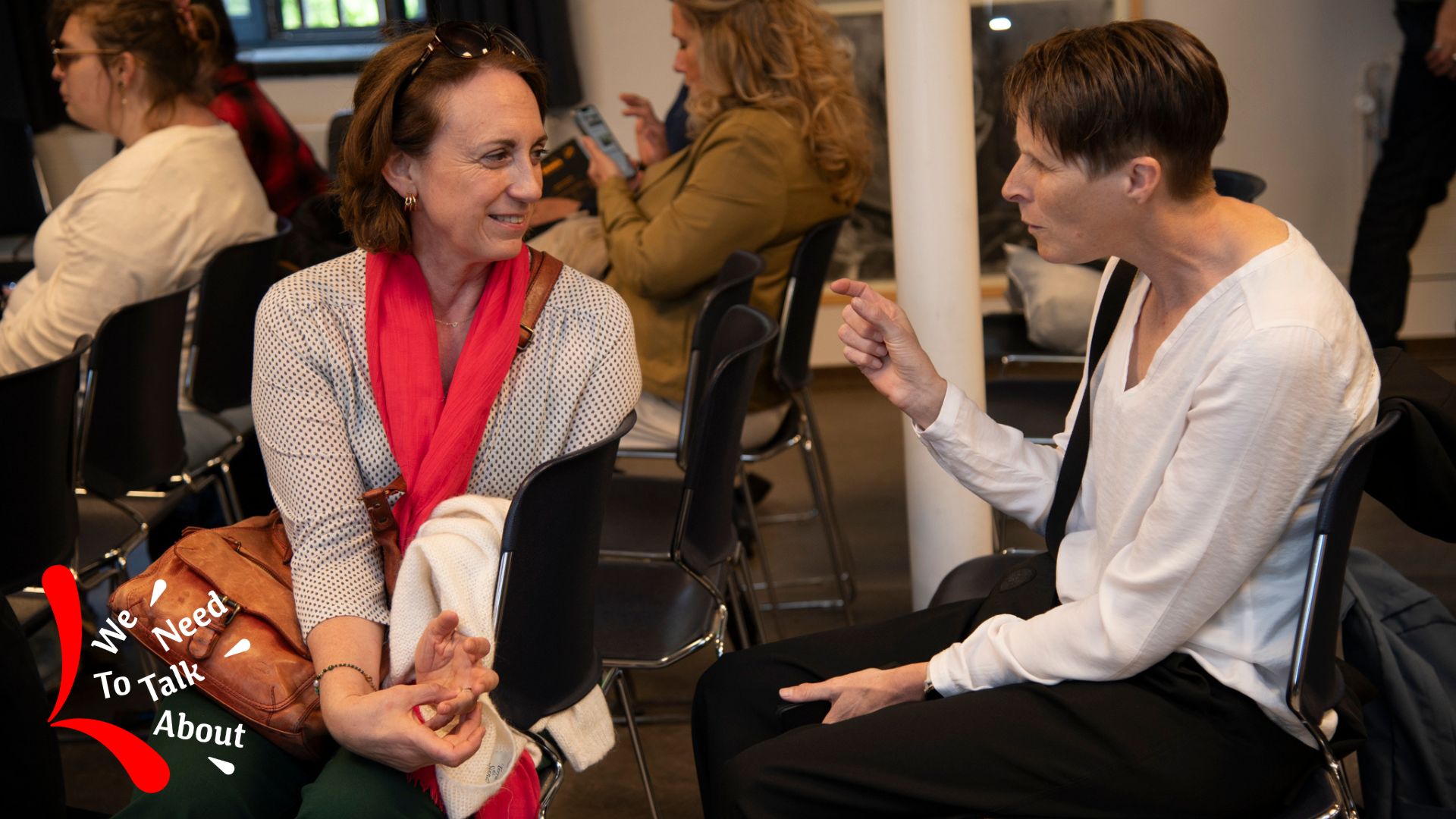 2 pratende vrouwelijke bezoekers op een activiteit van het Geuzenhuis