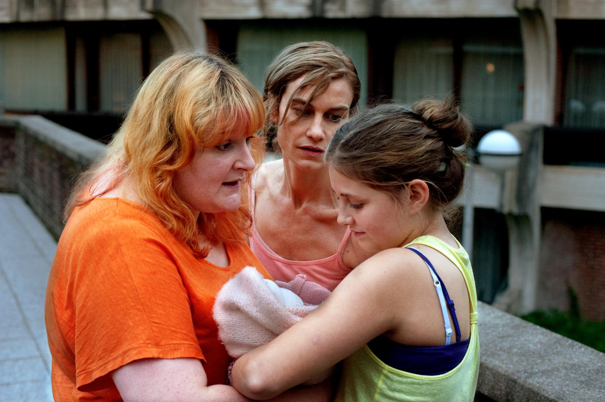 drie vrouwen houden een baby vast