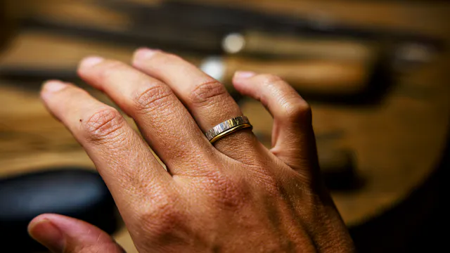 Hand met ambachtelijke zilveren ring
