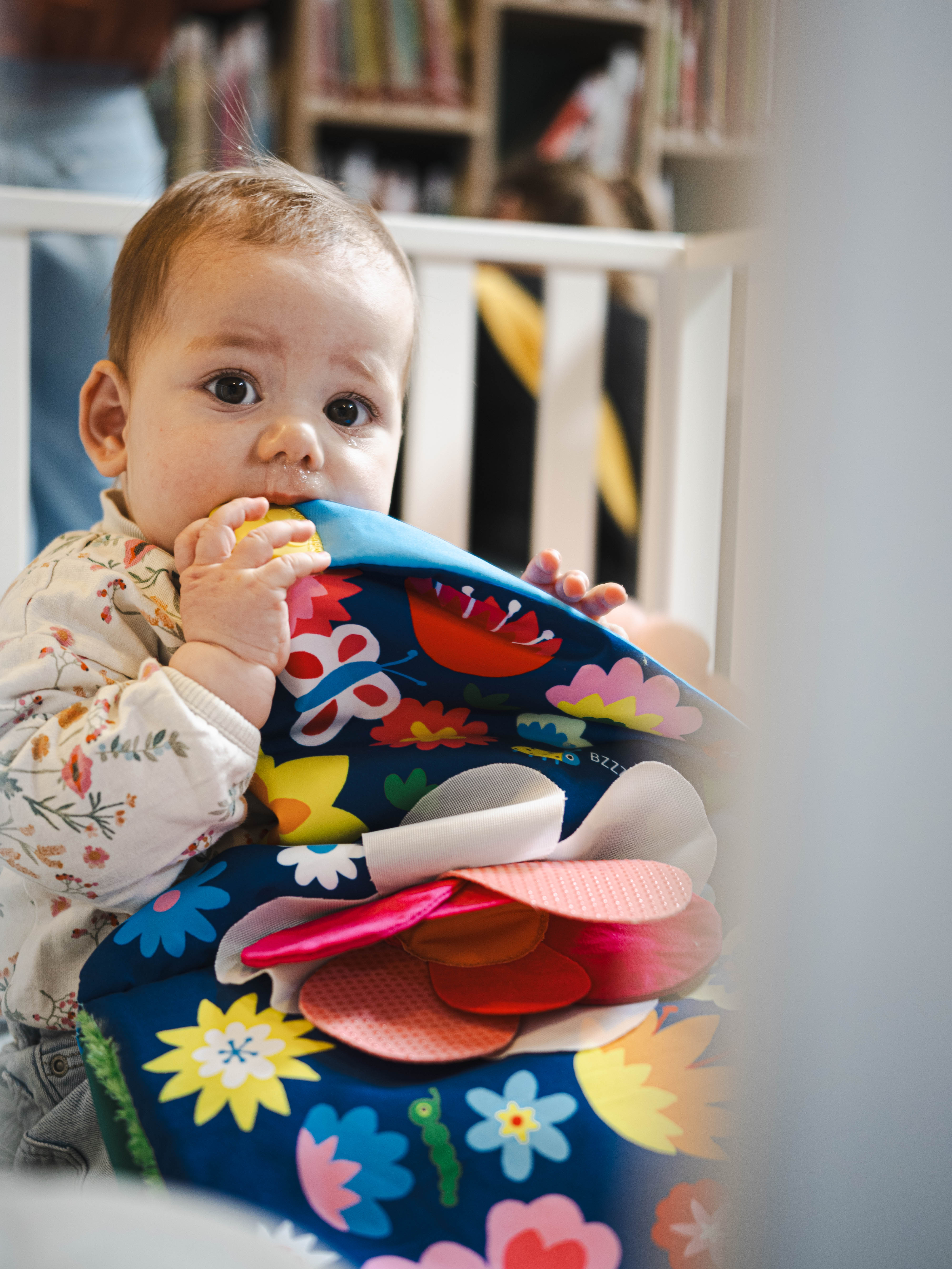Een baby sabbelt op een voelboekje