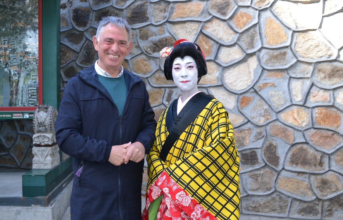 Foto van Noël Truyers langs een dame in traditionele kledij.