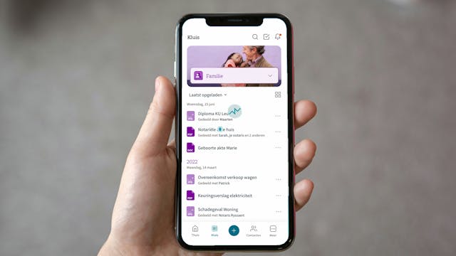 Persoon die smartphone vasthoudt waarop de app Izimi geopend is op de kluis 'Familie'
