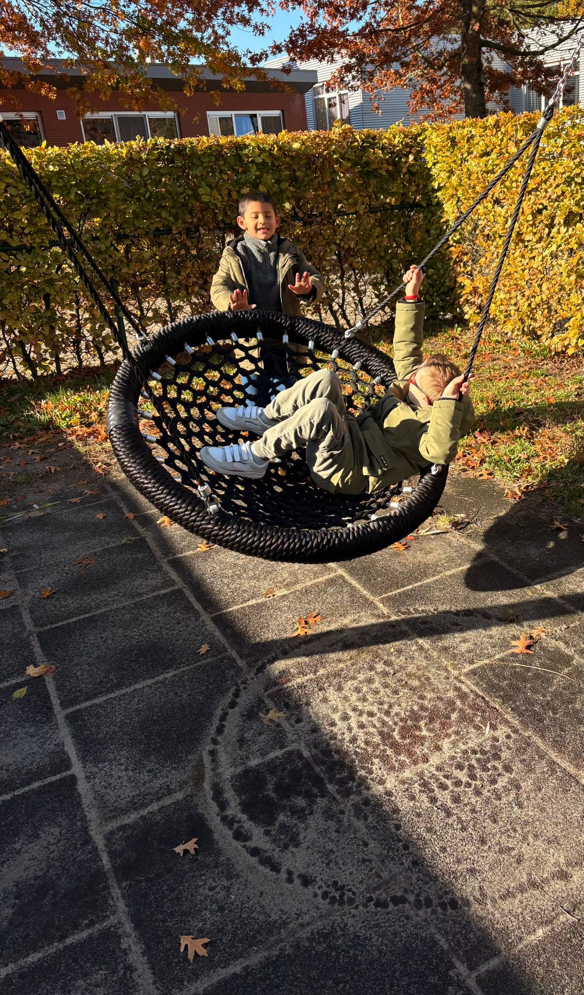 Kinderen spelen op nestschommel