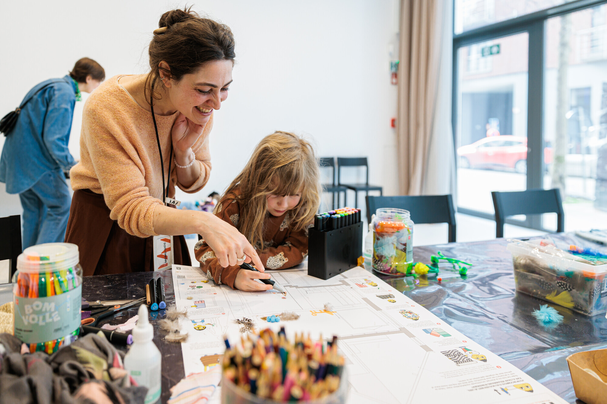 Gids helpt kindje met tekening