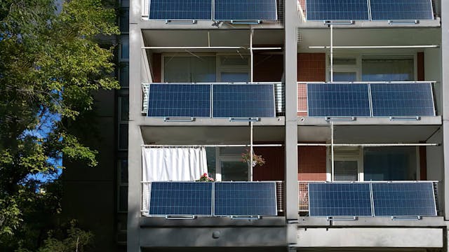 Zicht op een appartementsgebouw met stekkerpanelen.