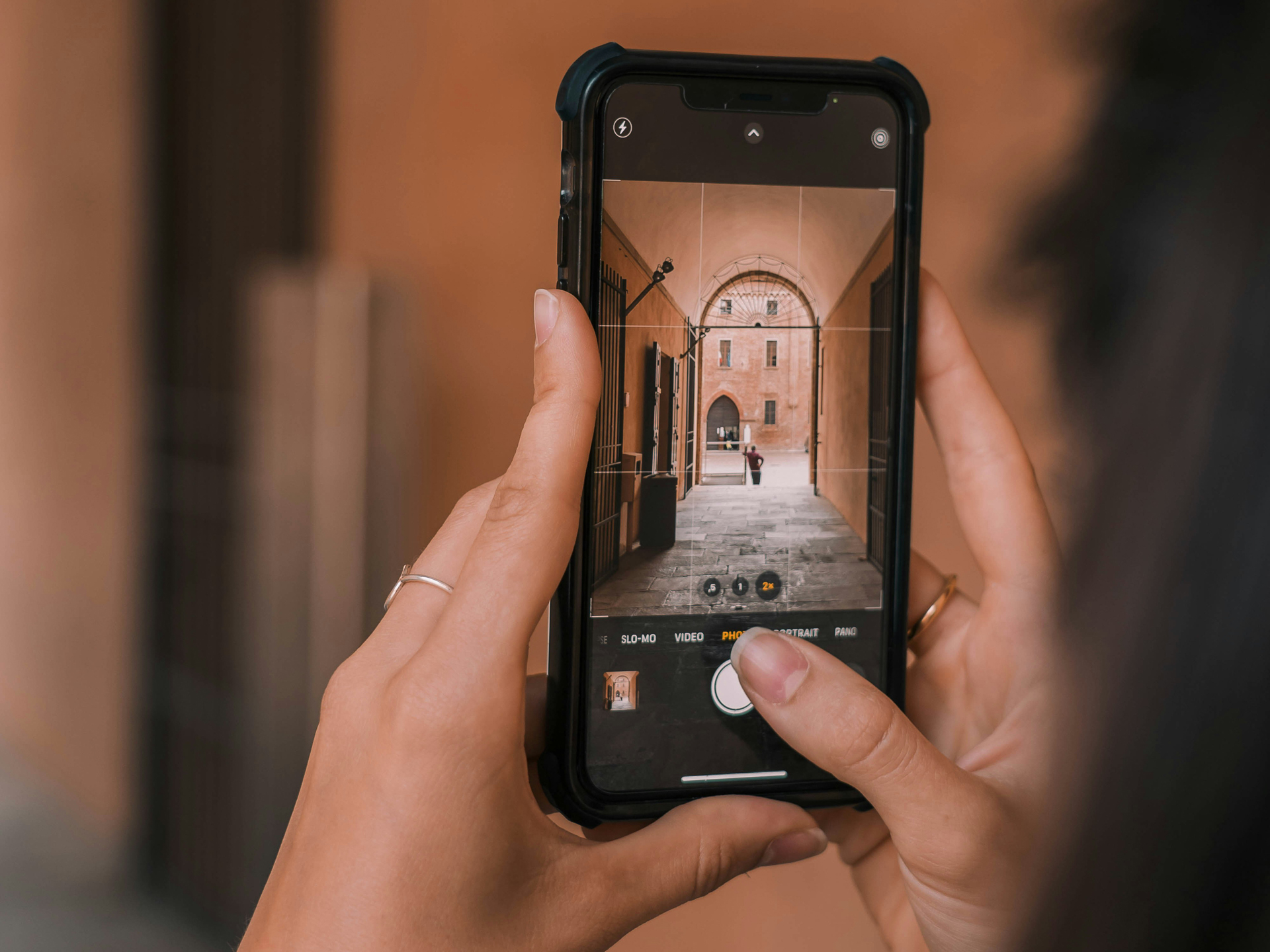 Handen die smartphone vasthouden en met de camera-app een foto nemen met behulp van rasterlijnen