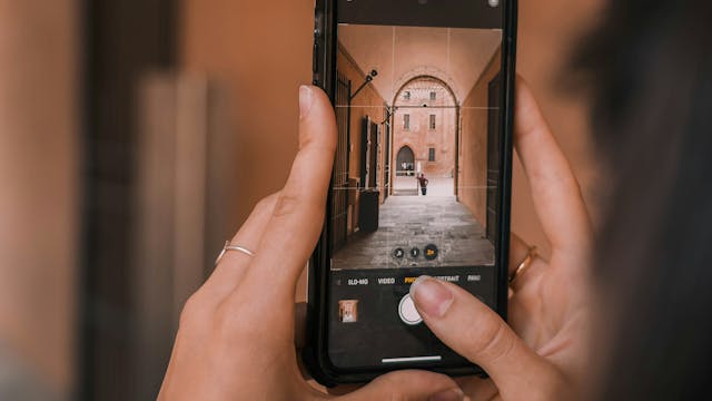 Handen die smartphone vasthouden en met de camera-app een foto nemen met behulp van rasterlijnen