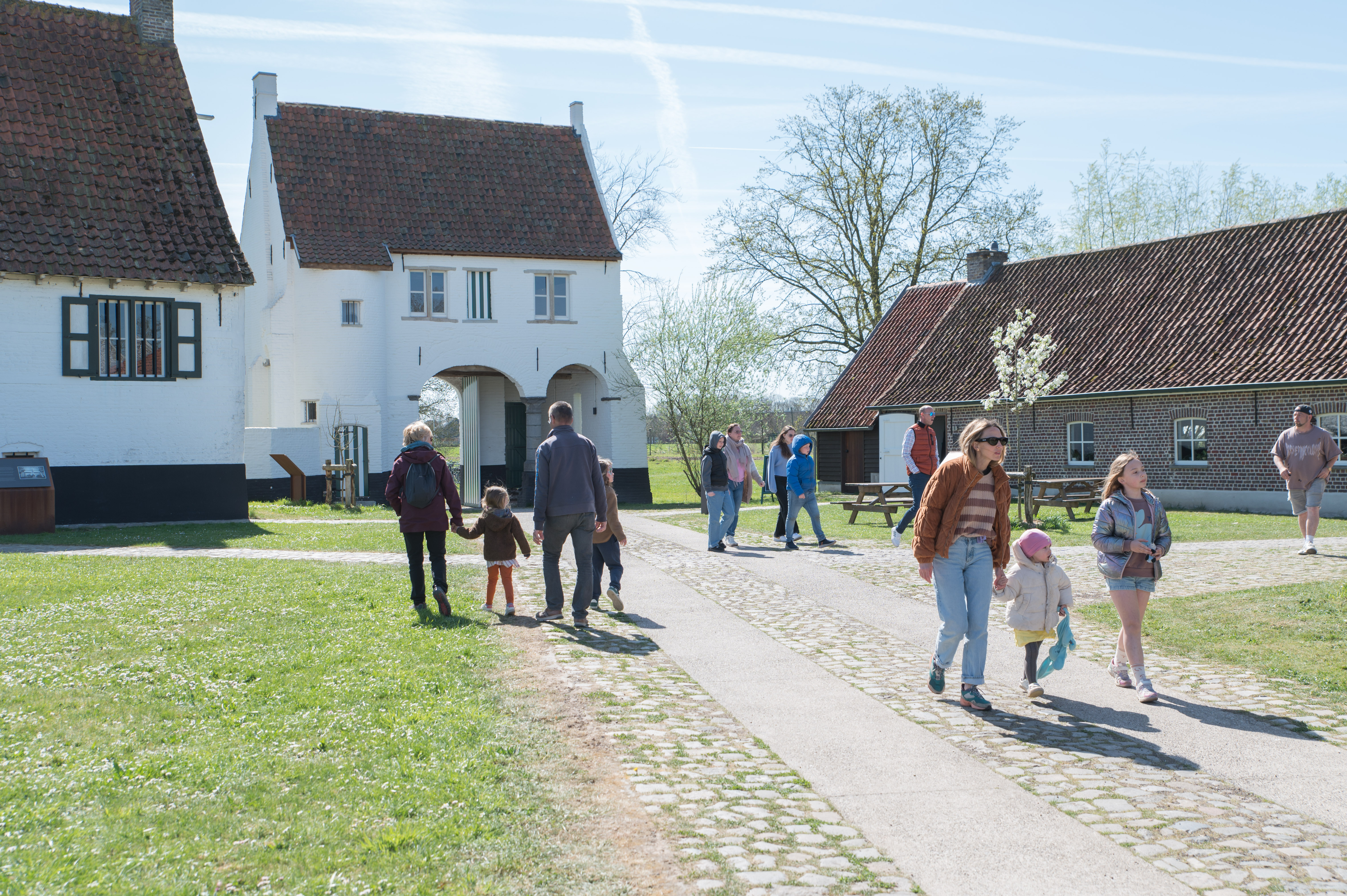 Bezoekers van de Huysmanhoeve met op de achtergrond het historische Poortgebouw