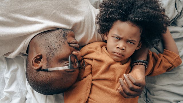 vader liggend in bed met boze zoon