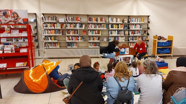 Volwassenen en kinderen luisteren naar verhaaltjes