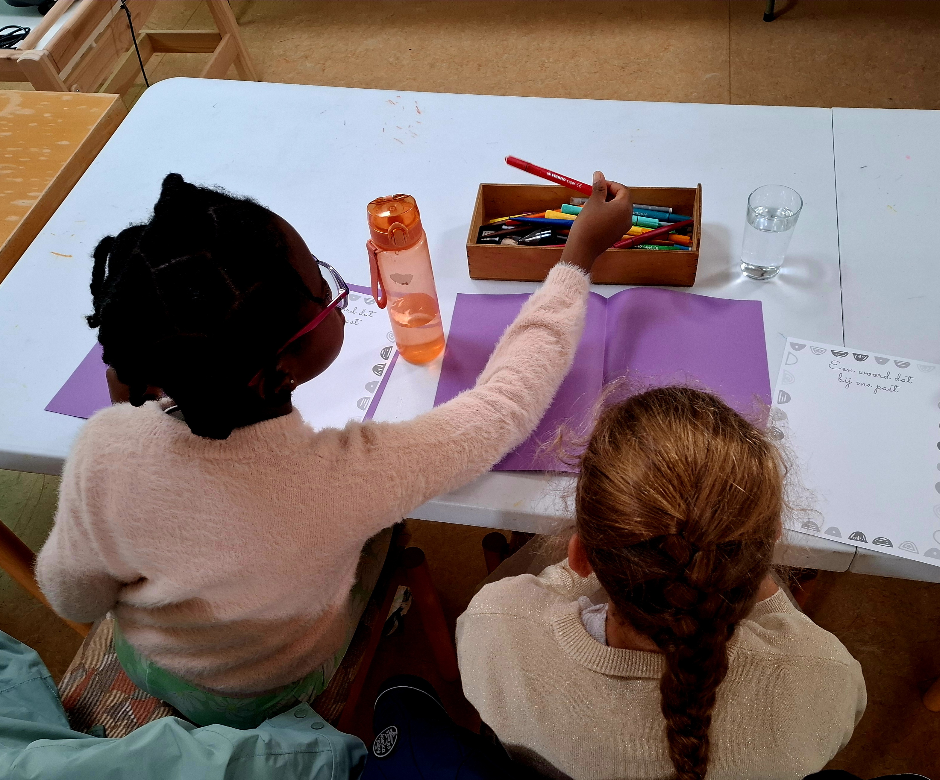2 kinderen creatief bezig in de bibliotheek