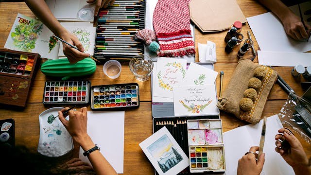 Bovenaanzicht van verschillende personen die aan het tekenen en schilderen zijn