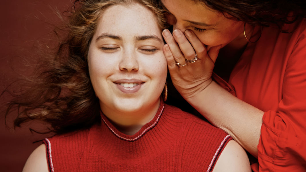 Moeder fluistert in oor van dochter