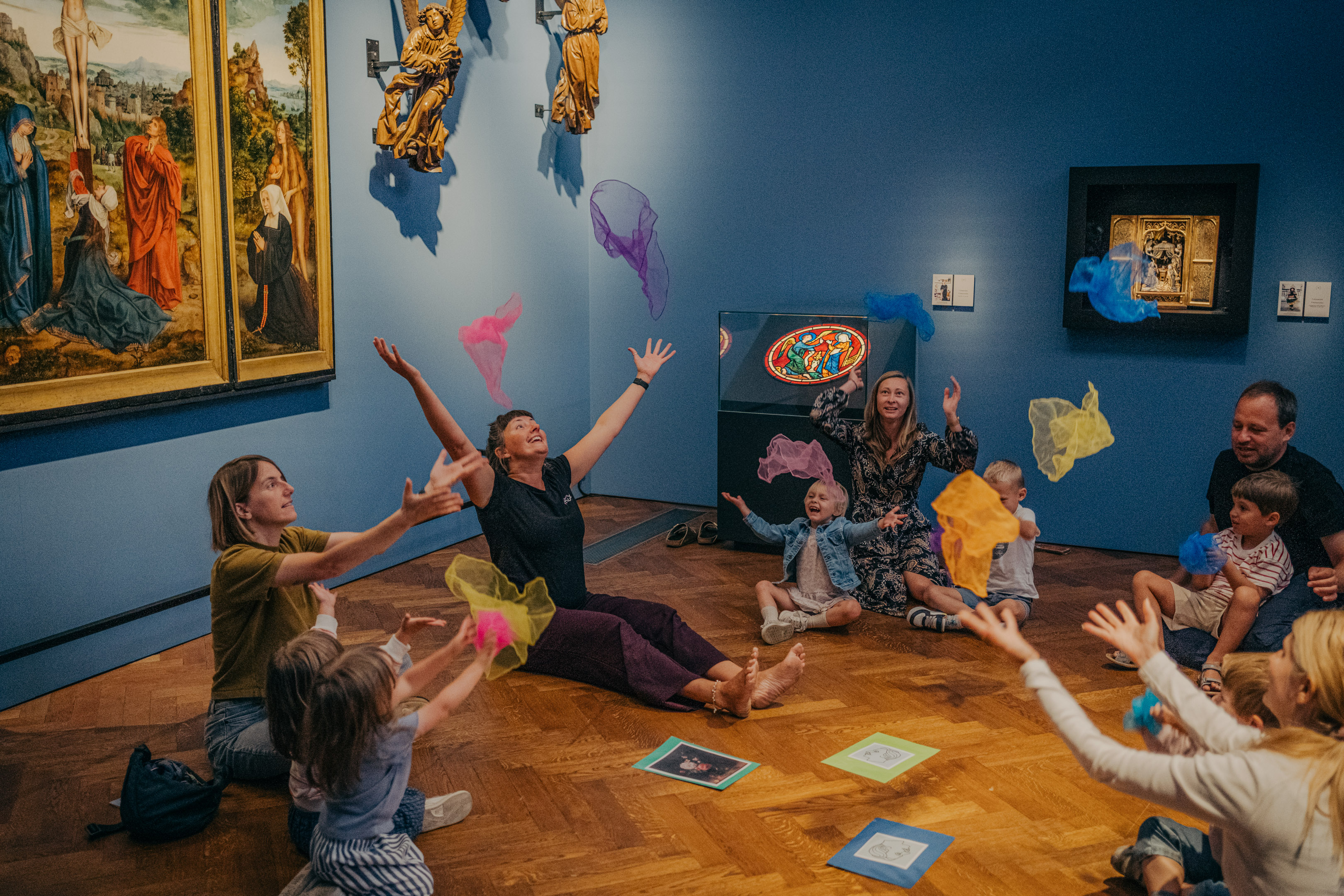 Kleuters en volwassenen maken plezier in een museumzaal.