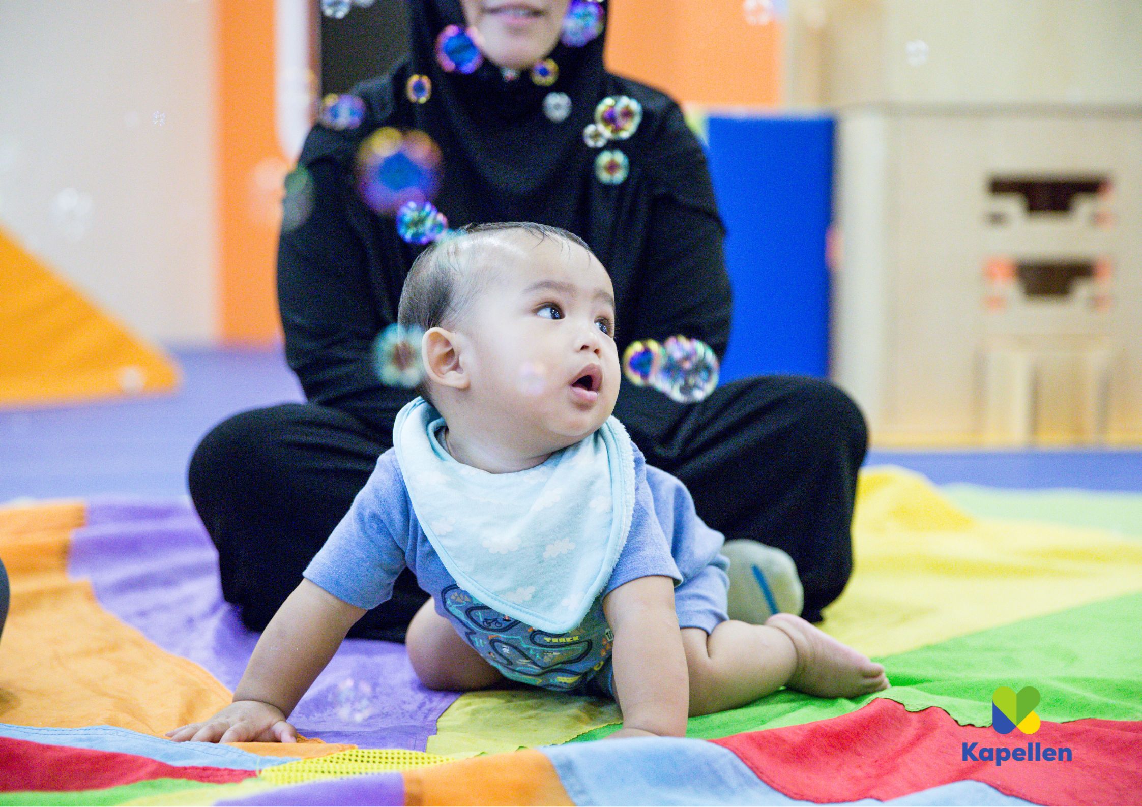 baby die in buiklig naar zeepbellen kijkt