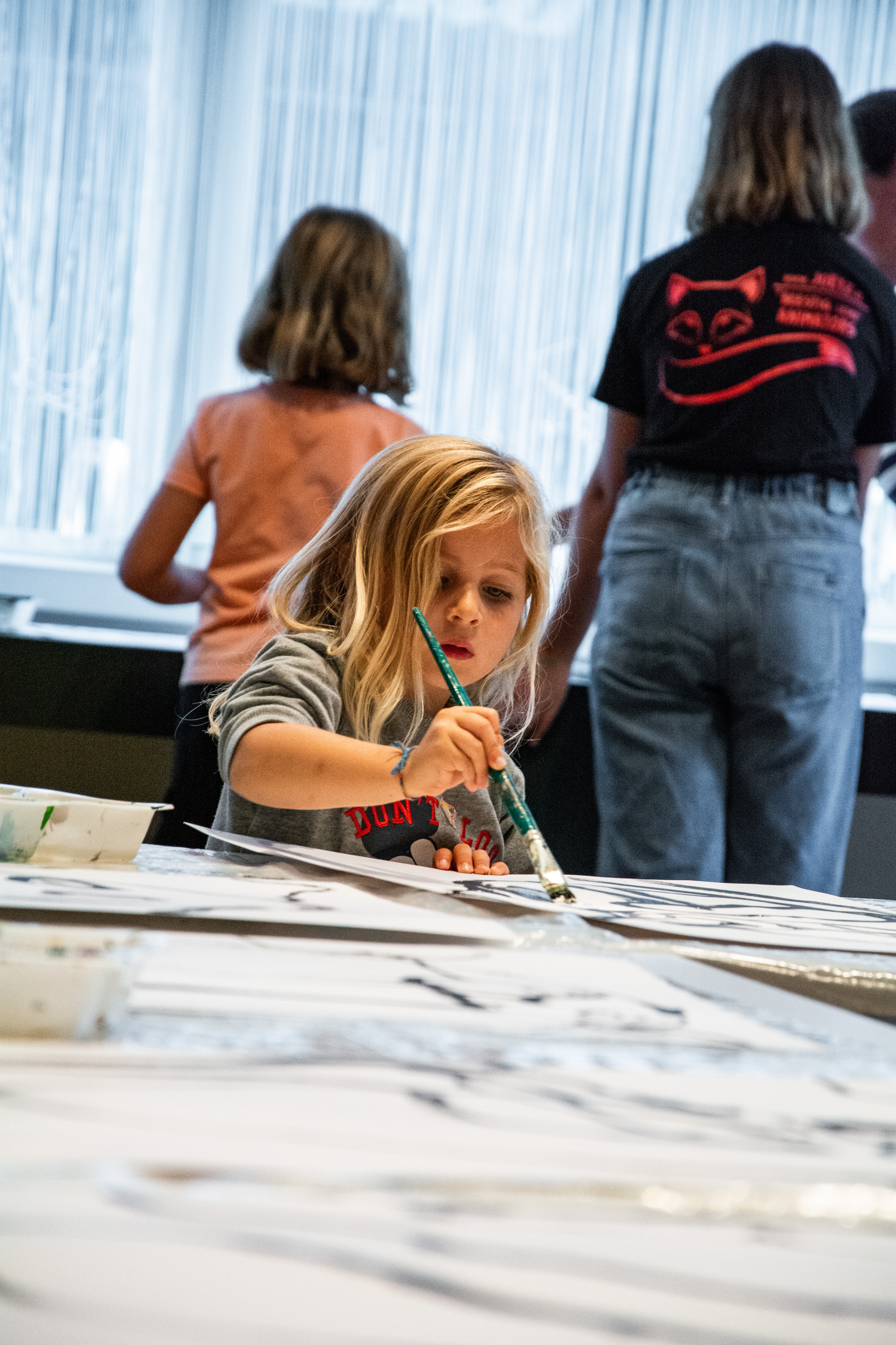 Kind zit aan het tafel en is aan het verven 