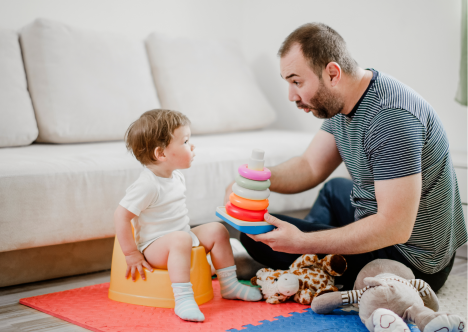 kindje op potje, papa op de grond met speelgoed