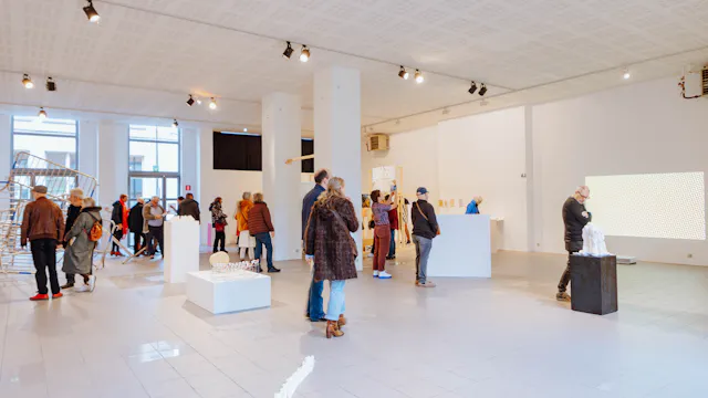 foto van de opening van expo Hulstaert vorig jaar, een overzichtsfoto met verschillende mensen op