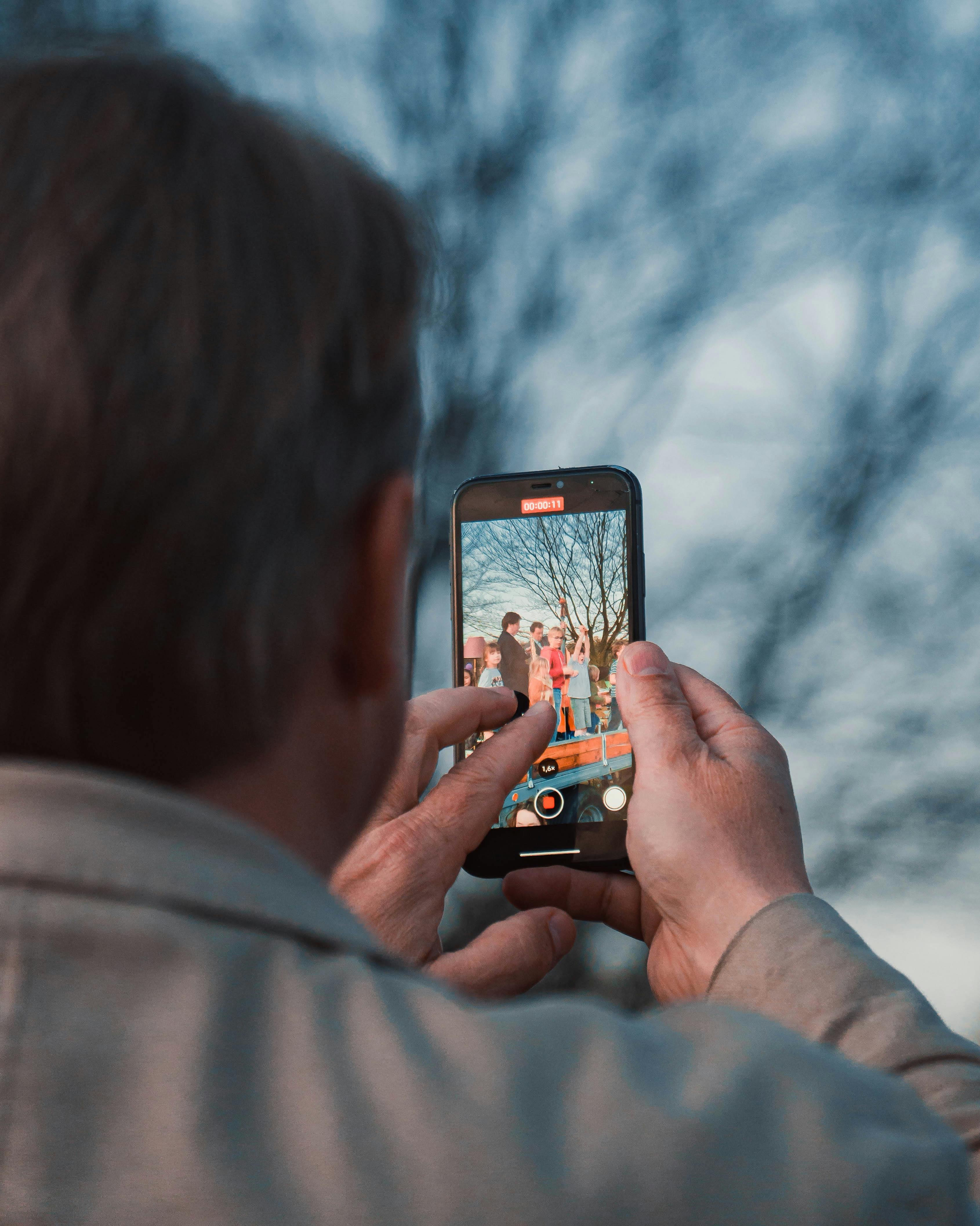 Man maakt met zijn smartphone een foto van een gezin