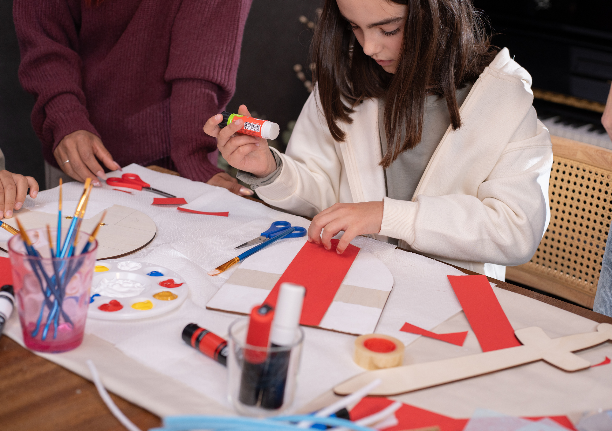 Een kind knutselt en een ouder helpt haar