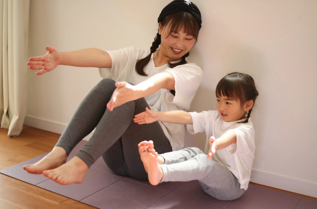 Vrouw en kind doen samen yoga