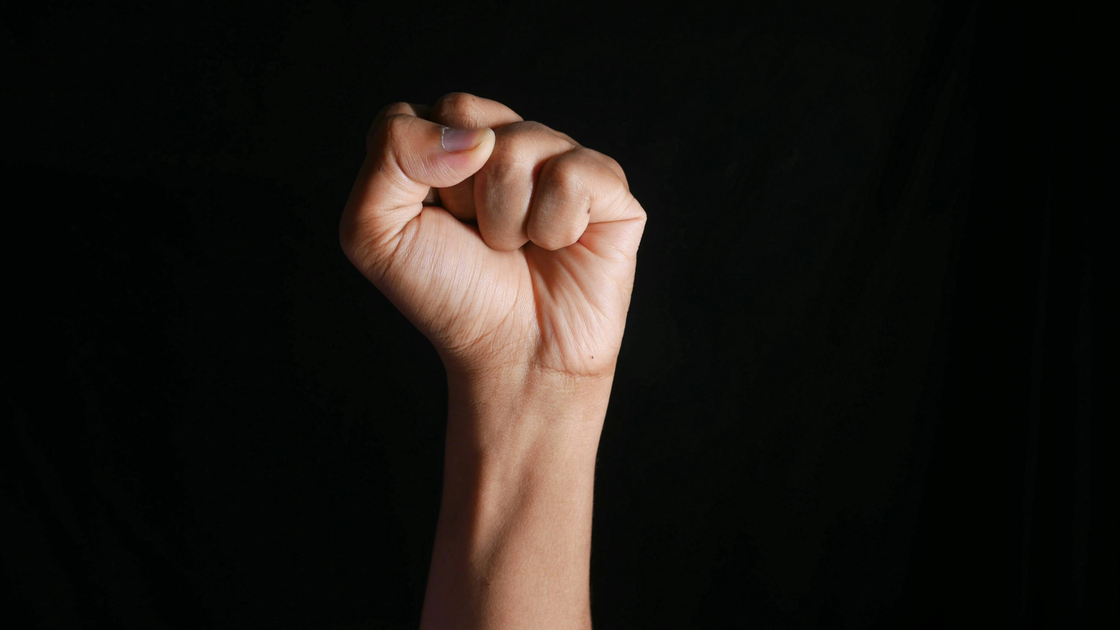 Gebalde vuist op een zwarte achtergrond