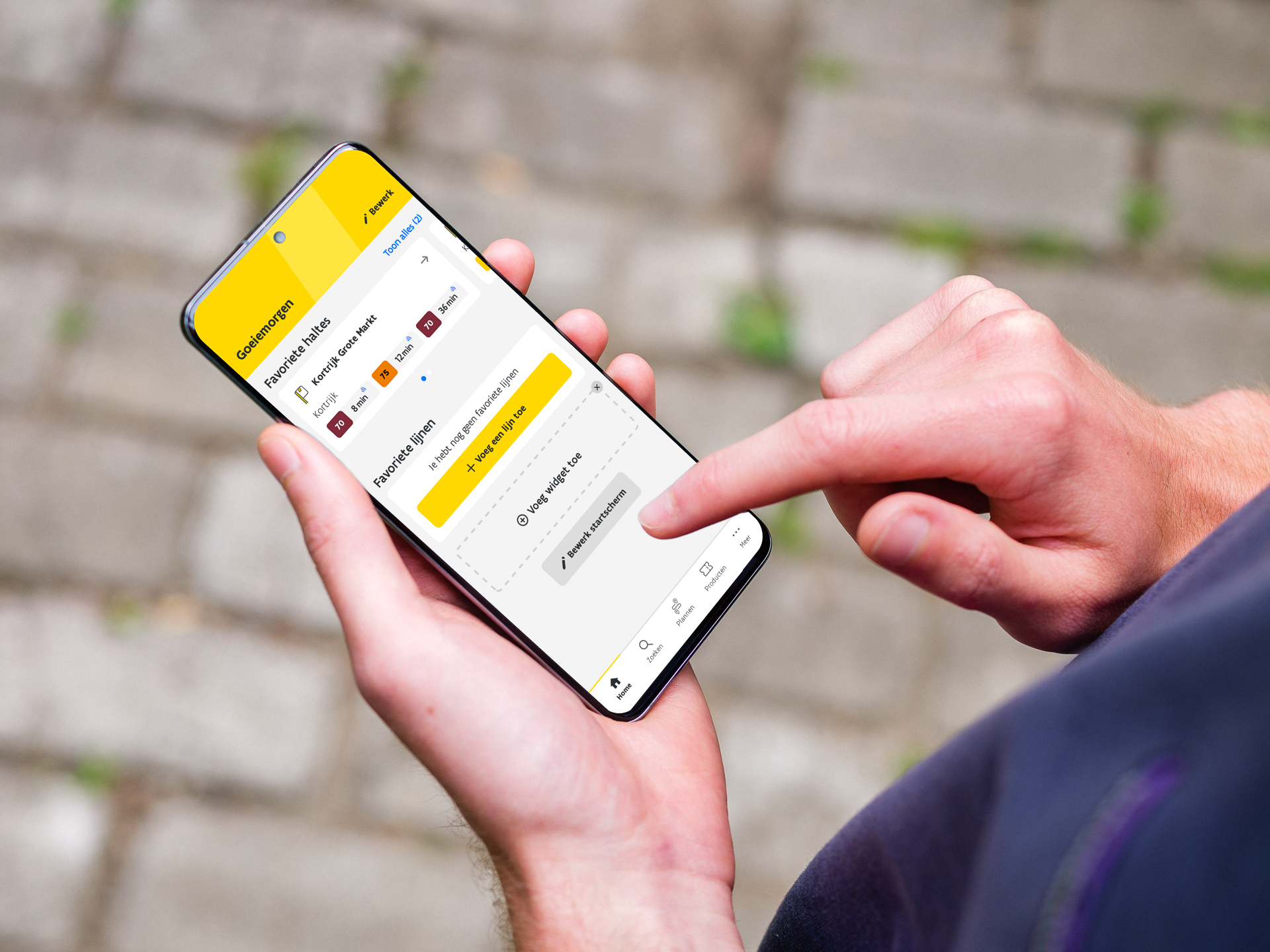 Persoon die in de app van De Lijn de favoriete lijnen en haltes aanpast