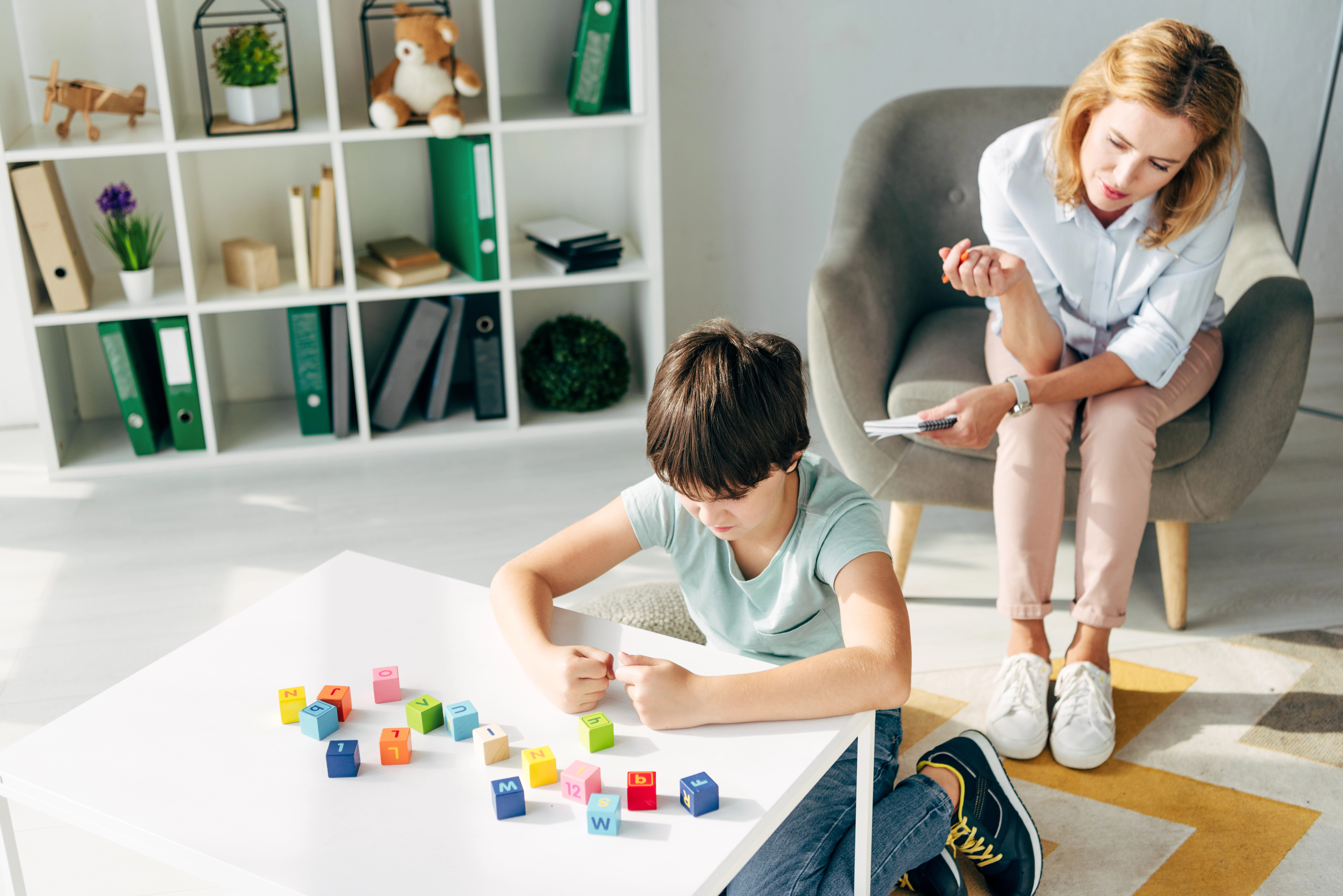Foto met kind aan tafel en vrouw in stoel