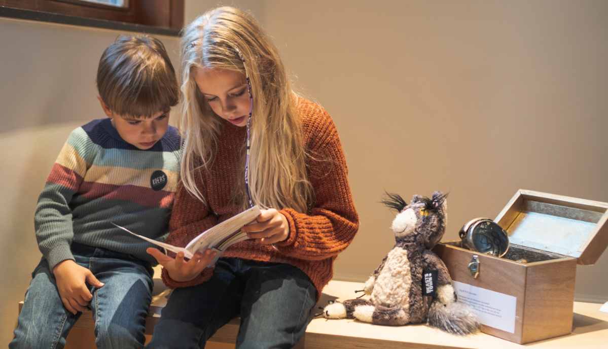 2 kinderen kijken in een boekje