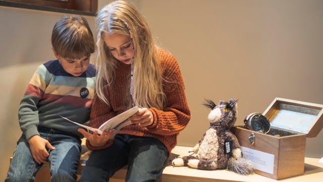 2 kinderen kijken in een boekje
