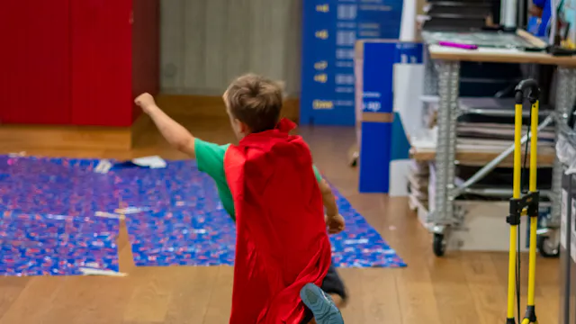 Kind met een cape loopt als superman