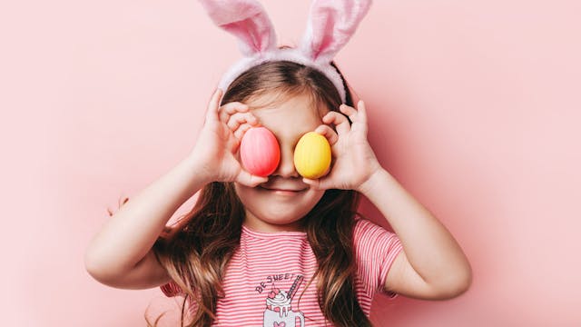 meisje met paashaasoren en paaseieren