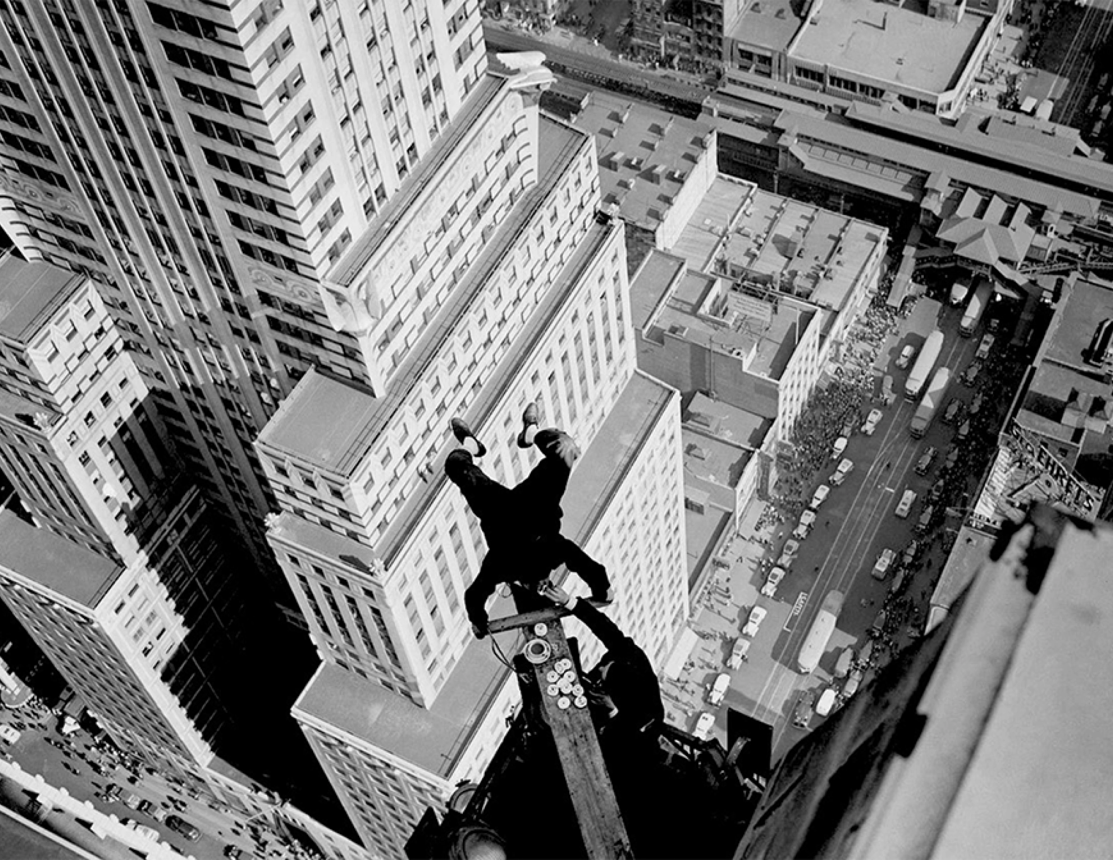 Alvin 'Shipwreck' Kelly, a professional flagpole sitter, eating dunked donuts whilst handstanding on the Chanin Building. Kelly ate 13 donuts during the stunt. (1939)