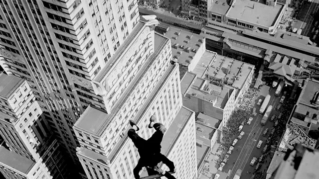 Alvin 'Shipwreck' Kelly, a professional flagpole sitter, eating dunked donuts whilst handstanding on the Chanin Building. Kelly ate 13 donuts during the stunt. (1939)