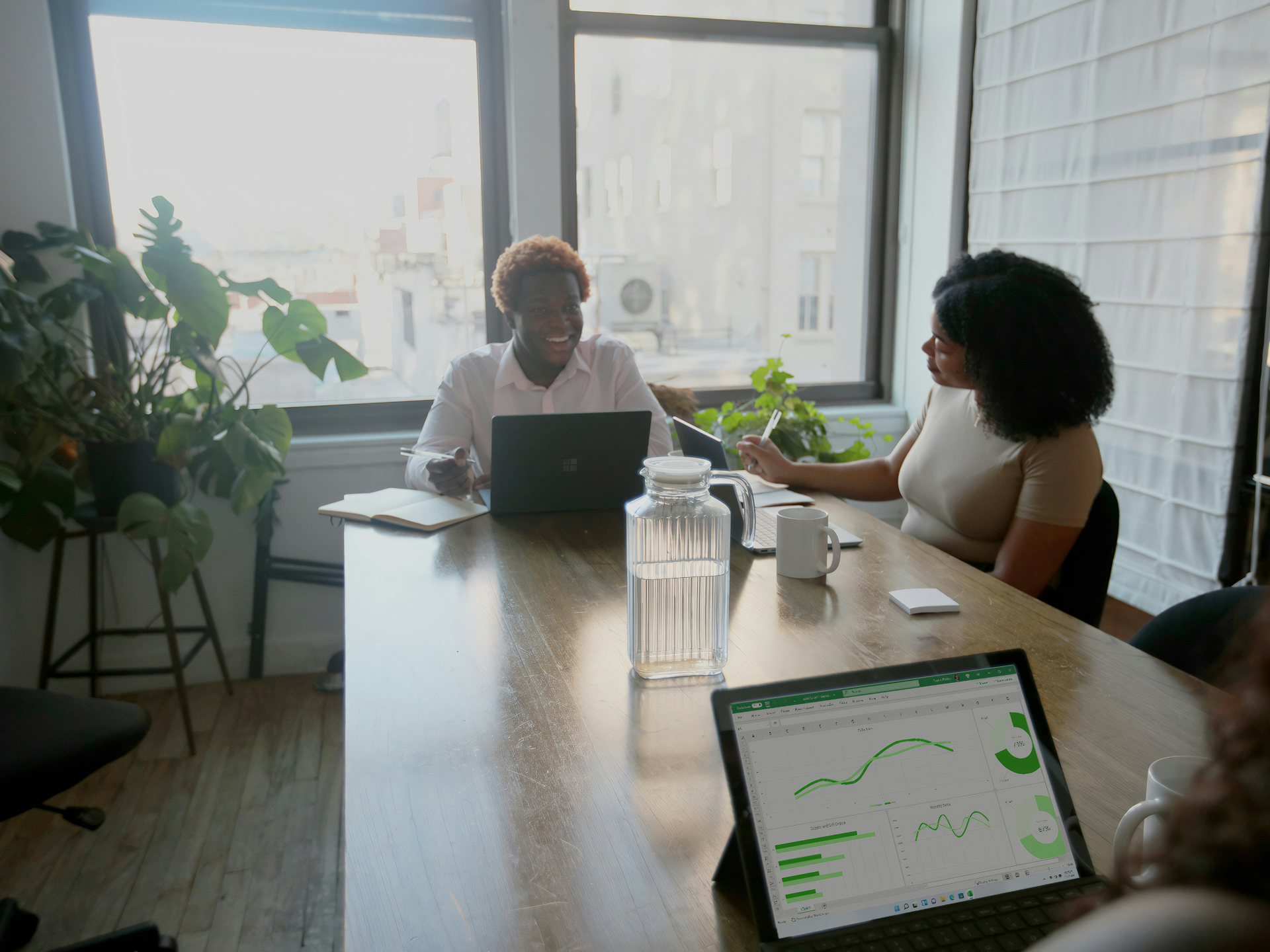 aantal personen met laptop aan een tafel, waarbij op 1 van de laptops heel wat grafieken te zien zijn