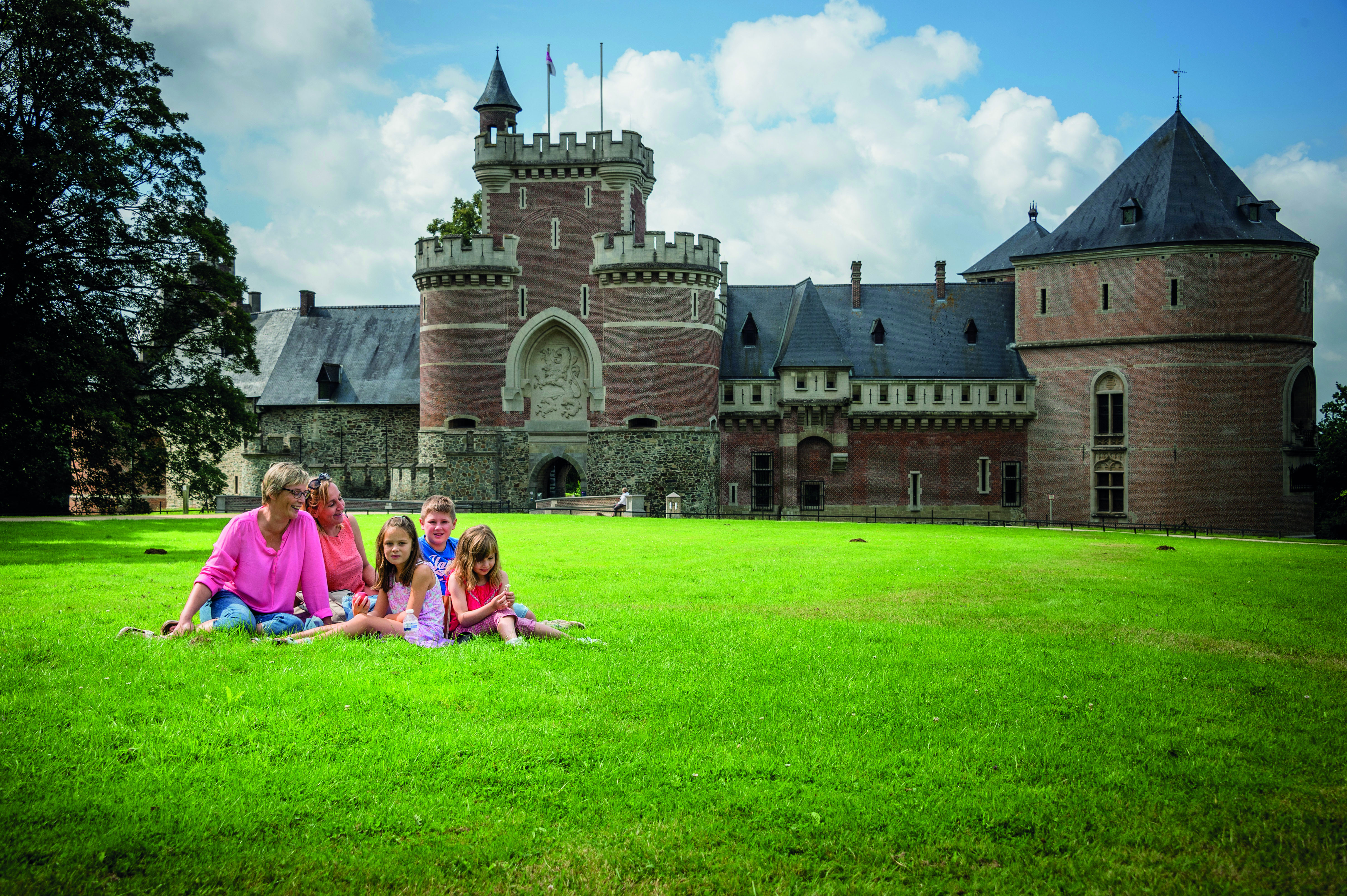 Gezellig in het gras picknicken voor de poort van het kasteel
