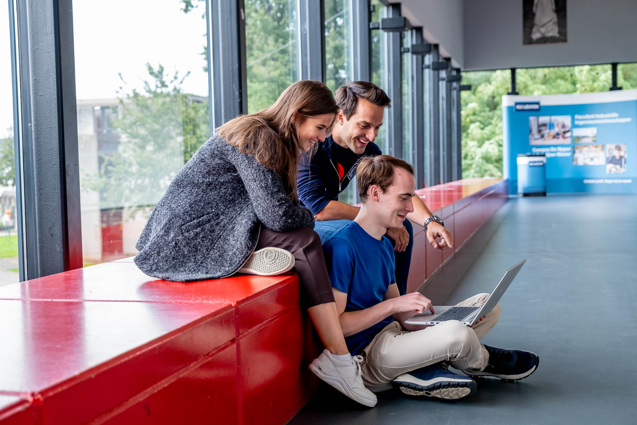 3 studenten werken aan een groepswerk op Campus De Nayer
